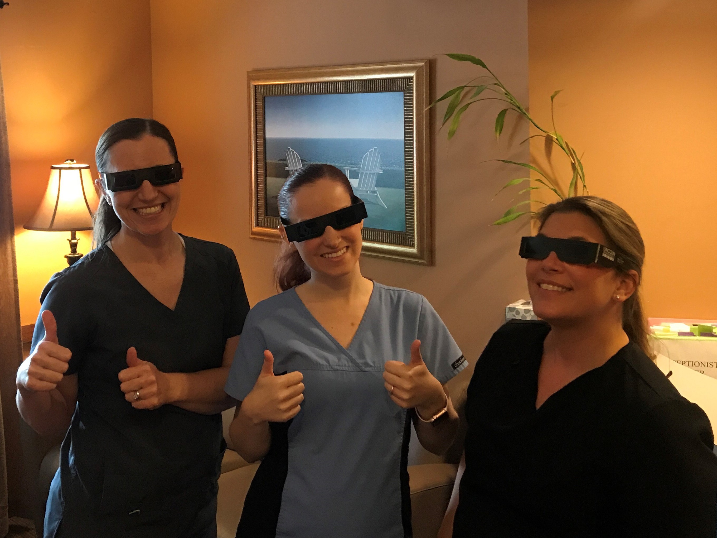 A picutre of Dr. Steckelber and staff wearing their solar glasses!